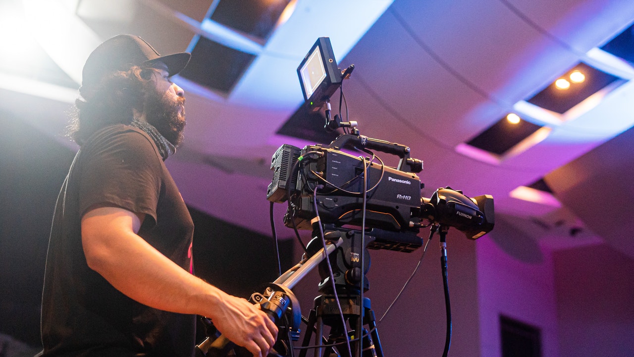 man using professional video camera to record event