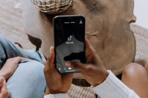 person holding phone with tiktok logo on screen